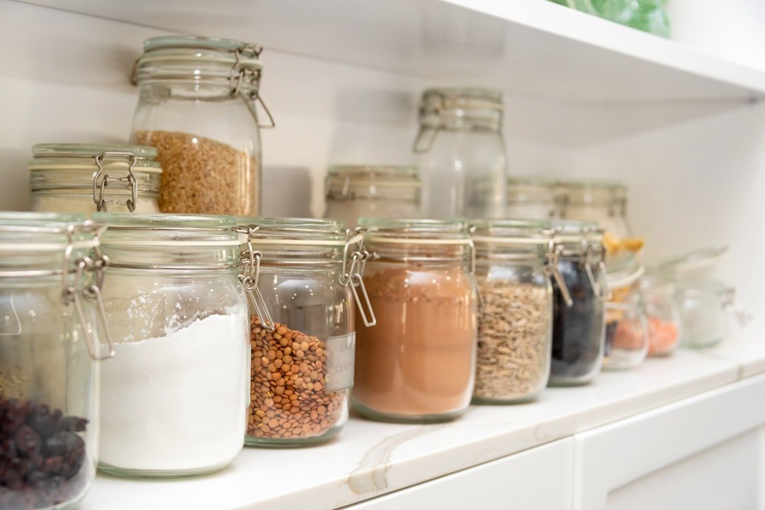 A neatly organized pantry with labeled jars, baskets, and shelves displaying a variety of food items, showcasing an efficient storage system.