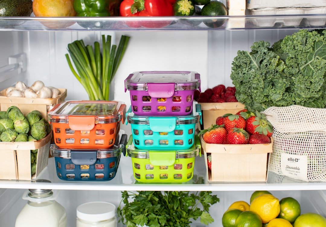 A neatly organized kitchen cabinet filled with various food storage containers, showcasing clear lids and matching sets for easy access.
